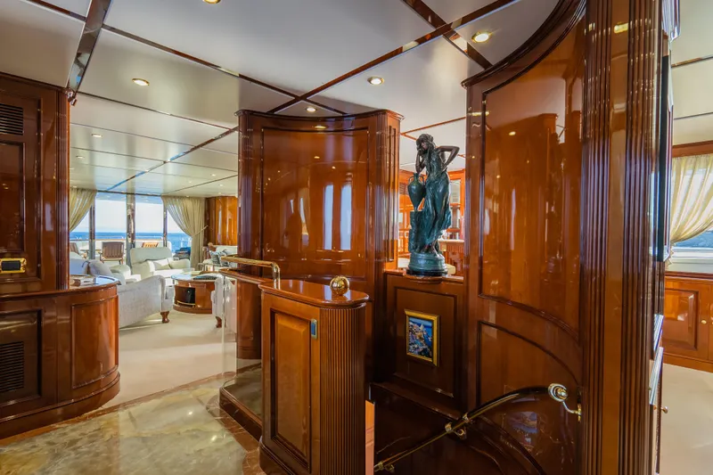 Stella Fiera Yacht Photos Pics Luxurious interior of 1998 Benetti Classic yacht with elegant wood paneling and sculpture.