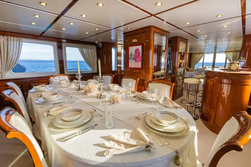 Stella Fiera Yacht Photos Pics Luxurious dining area on a 1998 Benetti Classic yacht, elegantly set table with ocean view.