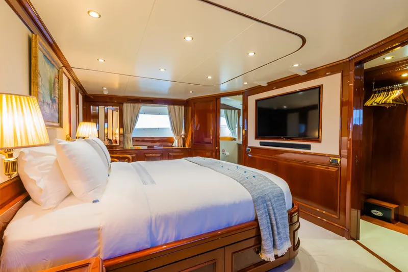 Stella Fiera Yacht Photos Pics Luxurious bedroom interior on 1998 Benetti Classic yacht, featuring elegant wood finishes and modern amenities.