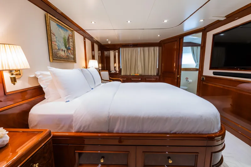 Stella Fiera Yacht Photos Pics Luxurious bedroom interior on 1998 Benetti Classic yacht, featuring elegant wood finishes and cozy lighting.