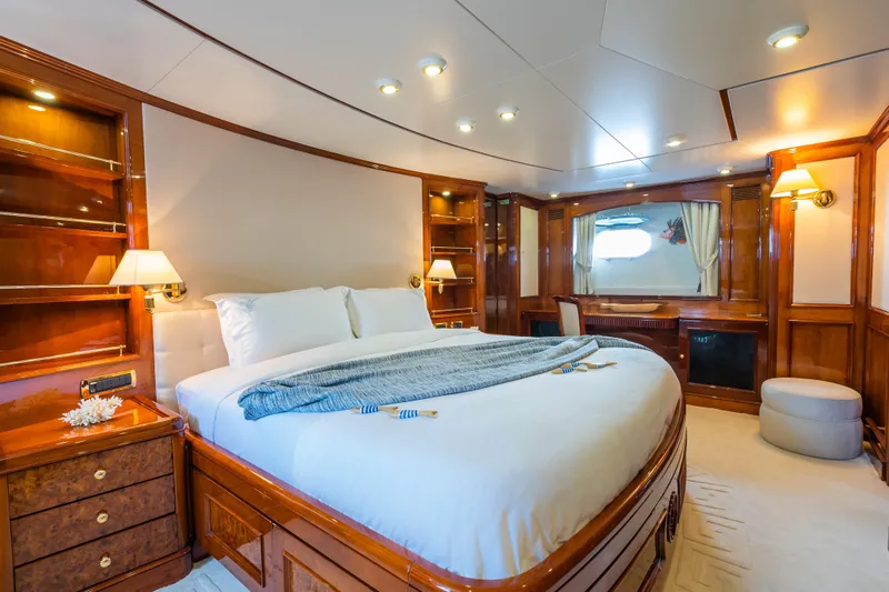 Stella Fiera Yacht Photos Pics Luxurious bedroom interior on 1998 Benetti Classic yacht with elegant wood finishes and cozy lighting.