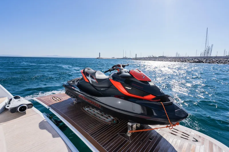 Stella Fiera Yacht Photos Pics Jet ski on Benetti Classic yacht deck, 1998 model, with ocean and lighthouse in background.