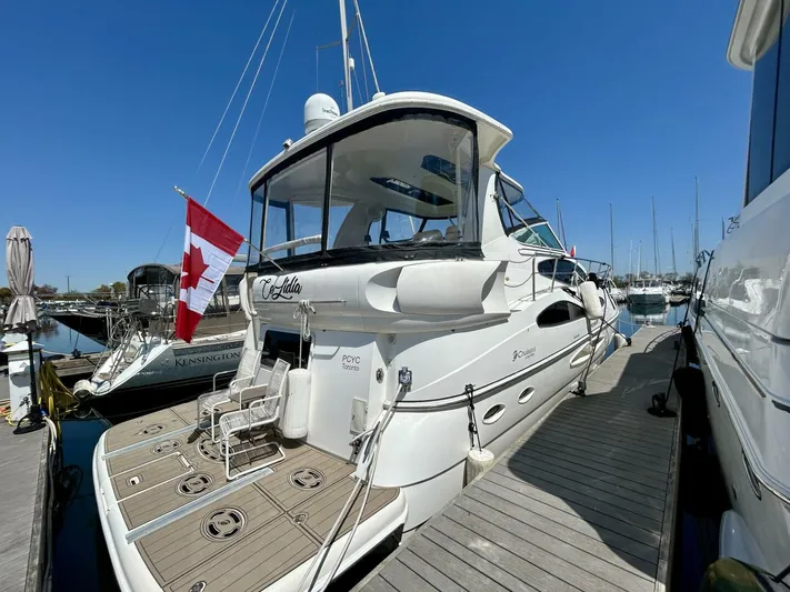 Yacht Photos Pics 2005 Cruisers Yachts 455 Express Motor Yacht docked with Canadian flag.