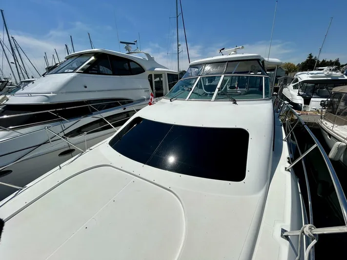  Yacht Photos Pics 2005 Cruisers Yachts 455 Express Motor Yacht docked in marina under clear blue sky.