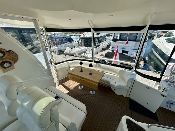  Yacht Photos Pics 2005 Cruisers Yachts 455 Express Motor Yacht interior with white seating and wooden table.