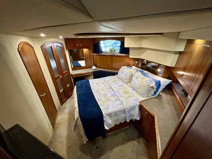  Yacht Photos Pics Luxurious 2005 Cruisers Yachts 455 Express Motor Yacht bedroom with elegant wood finishes.