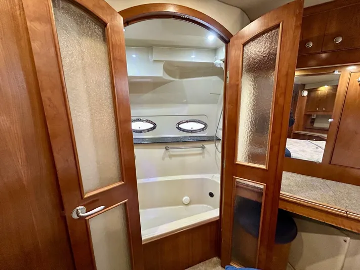 Yacht Photos Pics Luxurious bathroom in 2005 Cruisers Yachts 455 Express Motor Yacht with wooden doors and porthole windows.
