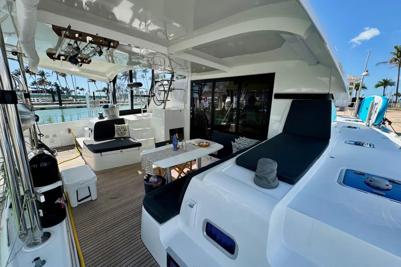 Island Hopp'r Owners Version Yacht Photos Pics Spacious deck of 2017 Lagoon 42 catamaran with seating and dining area, docked at marina.