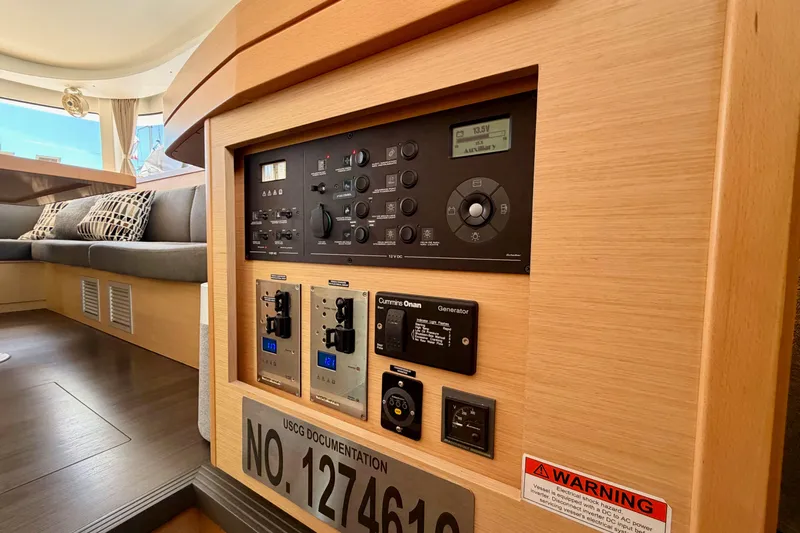 Island Hopp'r Owners Version Yacht Photos Pics Control panel inside a 2017 Lagoon 42 catamaran, featuring electrical switches and warning label.