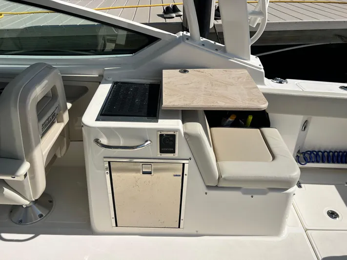  Yacht Photos Pics 2023 Boston Whaler 280 Vantage interior with seating and kitchenette area.