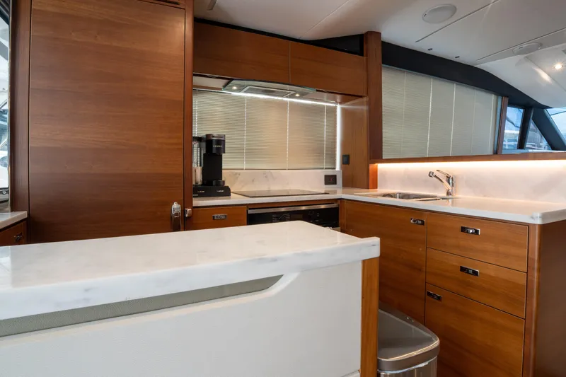  Yacht Photos Pics Luxurious kitchen interior of 2020 Princess S66 yacht with modern wood cabinetry and marble countertops.