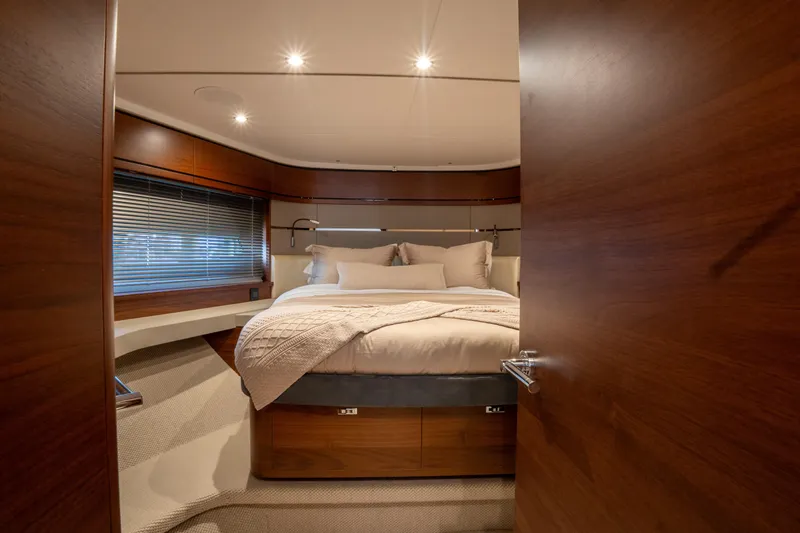  Yacht Photos Pics Luxurious bedroom interior of 2020 Princess S66 yacht with elegant wood finishes.