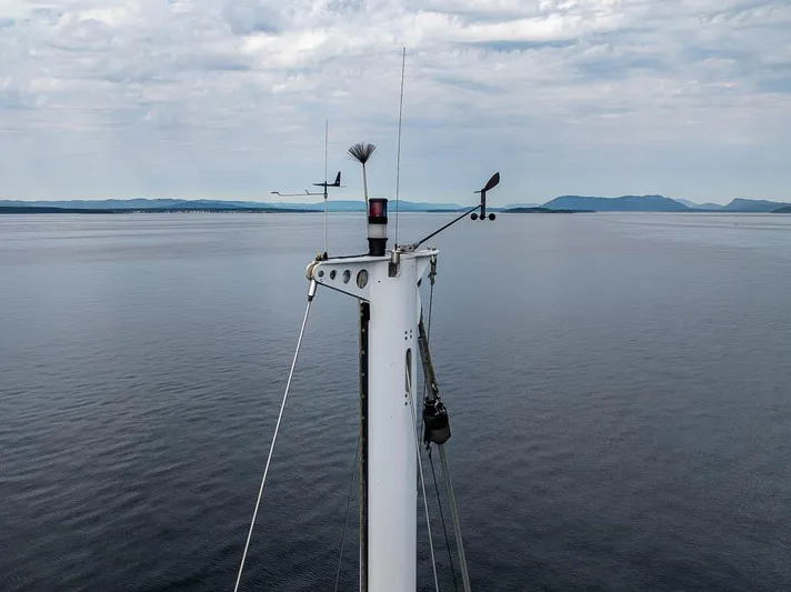 Koh - I - Noor Yacht Photos Pics Mast of 1974 C&C 61 sailboat against calm sea and cloudy sky.