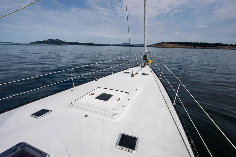 Koh - I - Noor Yacht Photos Pics Sailing on a 1974 C&C 61 yacht, calm waters, scenic coastal view.