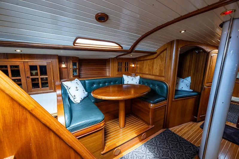 Koh - I - Noor Yacht Photos Pics Interior of a 1974 C&C 61 yacht with wooden paneling and green cushioned seating.