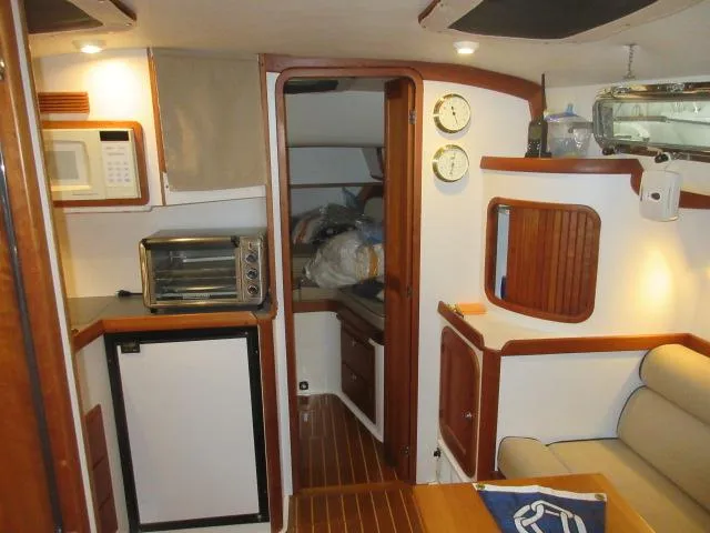  Yacht Photos Pics Interior of 2003 Legacy Yachts 34 Sedan with kitchenette and seating area.