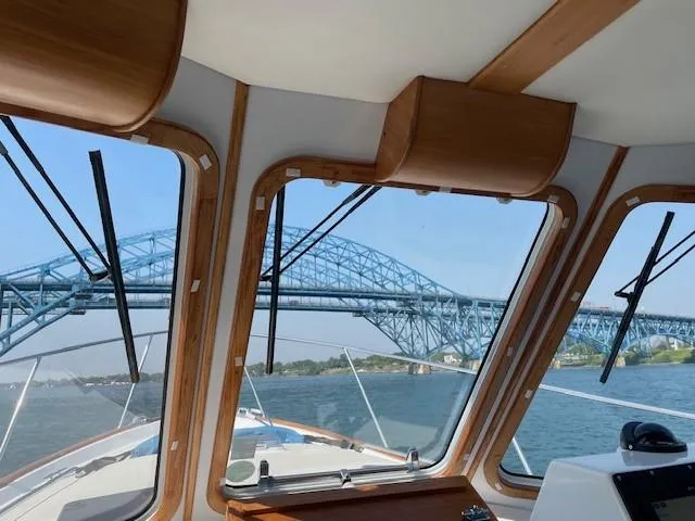  Yacht Photos Pics Interior view from 2003 Legacy Yachts 34 Sedan, overlooking a blue bridge on a sunny day.