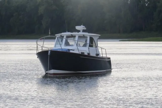  Yacht Photos Pics 2003 Legacy Yachts 34 Sedan on calm water, surrounded by trees.