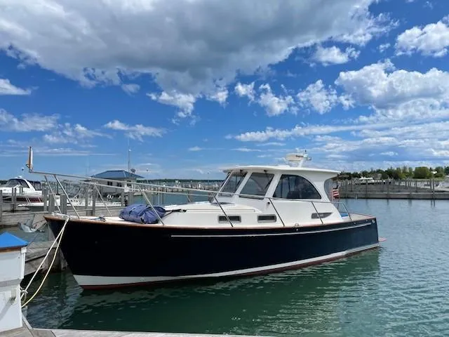  Yacht Photos Pics 2003 Legacy Yachts 34 Sedan docked under a partly cloudy sky.