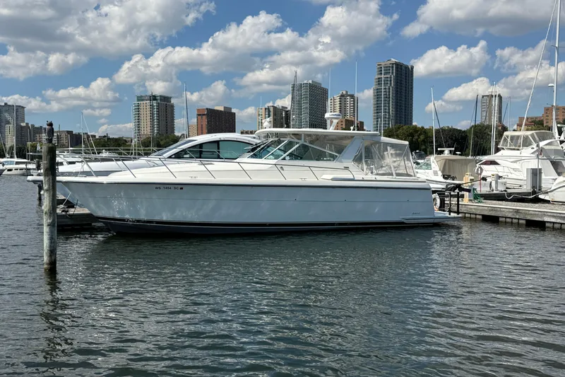  Yacht Photos Pics 1994 Tiara Yachts 4000 Express docked in marina with city skyline backdrop.