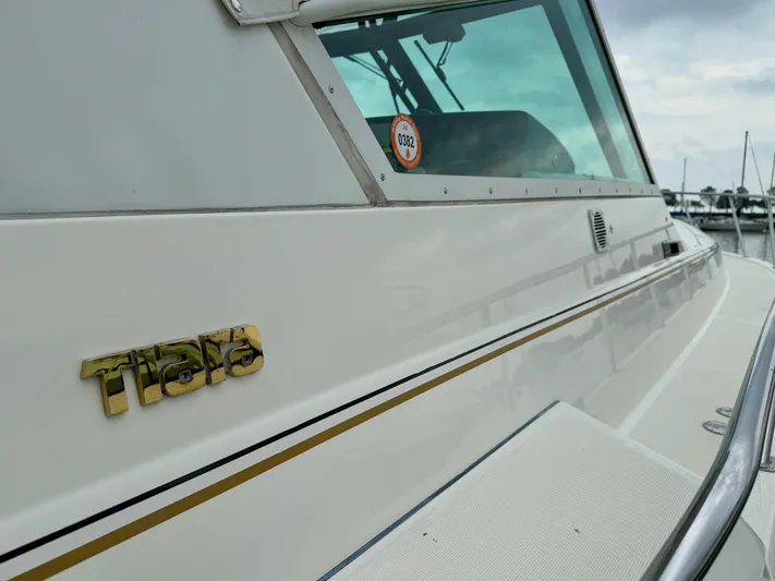  Yacht Photos Pics 2004 Tiara Yachts 4000 Express, side view with logo and marina background.