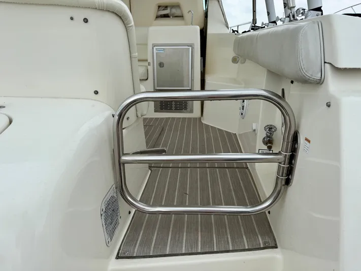  Yacht Photos Pics 2004 Tiara Yachts 4000 Express interior with stainless steel gate and cushioned seating.