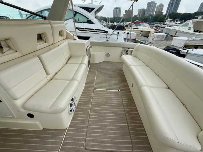  Yacht Photos Pics 2004 Tiara Yachts 4000 Express interior with beige seating and wood flooring at a marina.