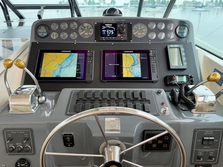  Yacht Photos Pics Control panel of a 2004 Tiara Yachts 4000 Express with navigation screens and steering wheel.