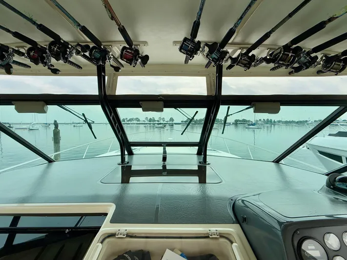 Yacht Photos Pics 2004 Tiara Yachts 4000 Express interior with fishing rods, overlooking a serene marina.