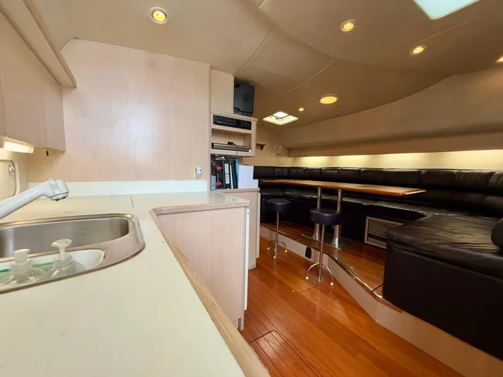  Yacht Photos Pics 2004 Tiara Yachts 4000 Express interior with kitchen, seating area, and wooden flooring.