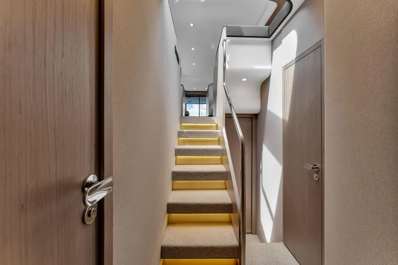  Yacht Photos Pics Interior staircase of 2022 Azimut Fly 60 yacht, featuring modern design and ambient lighting.