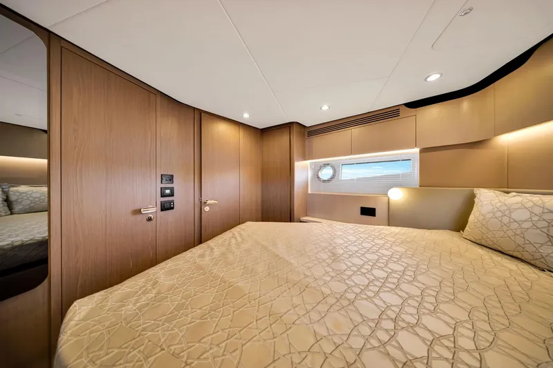  Yacht Photos Pics Luxurious bedroom interior of 2022 Azimut Fly 60 yacht with elegant wood paneling.