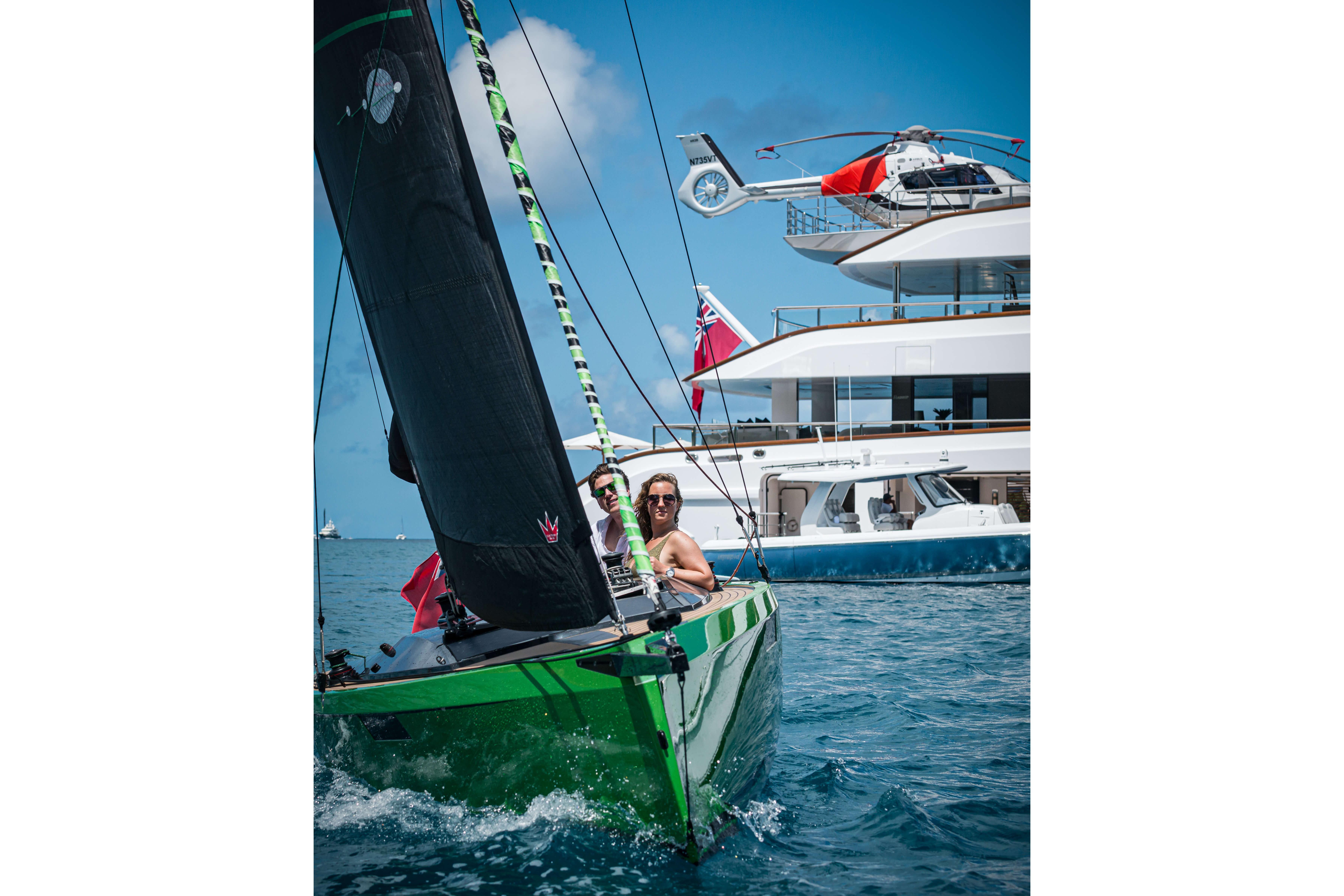 Saffier SE24 Lite sailboat sailing near luxury yacht with helicopter, 2026 model.