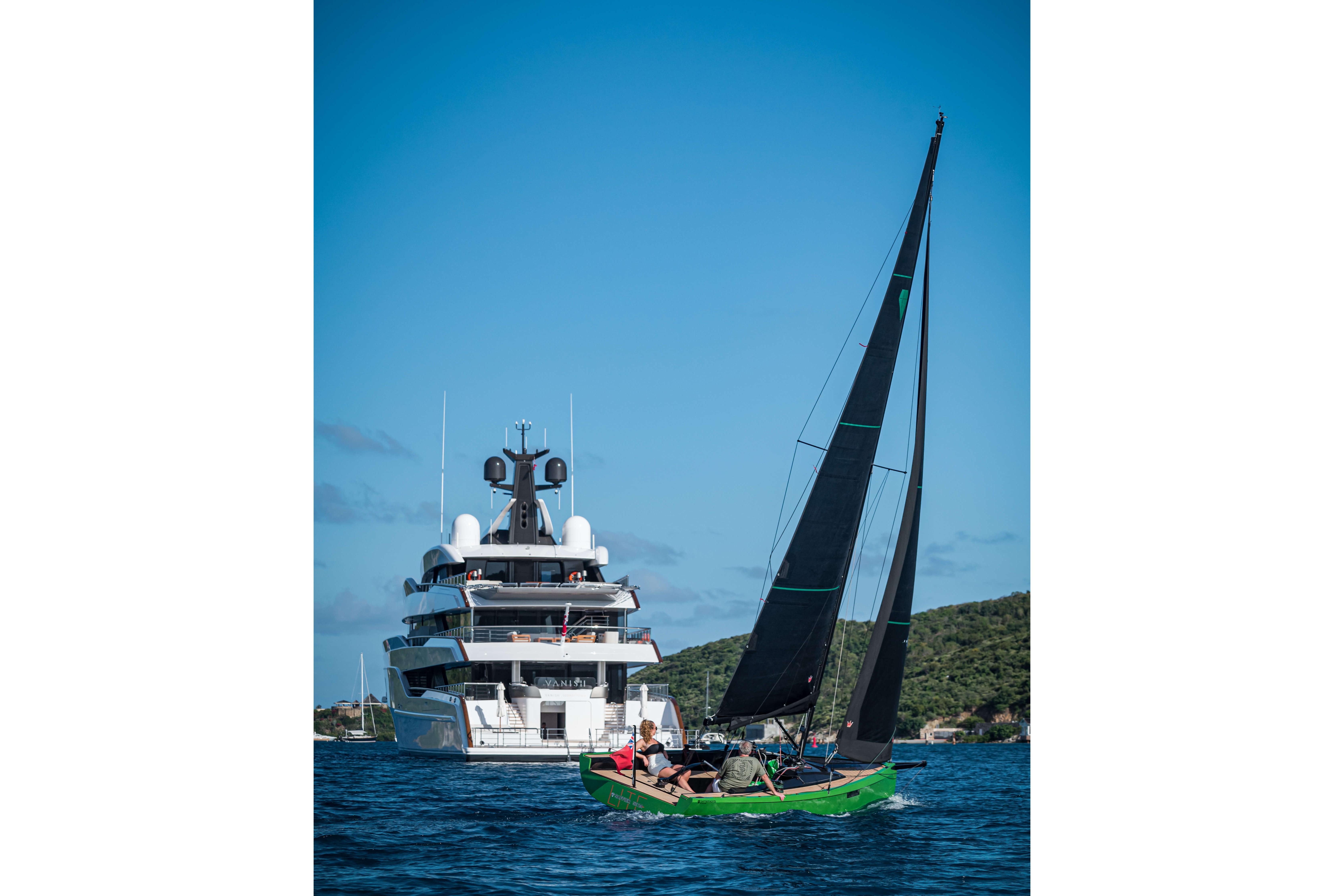 Saffier SE24 Lite 2026 sailing near a large yacht on a sunny day.