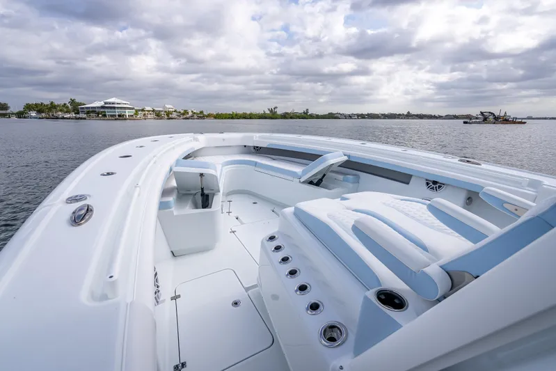 New Stock 42 Offshore Yacht Photos Pics 2026 Yellowfin 42 Offshore boat with spacious deck, docked on a calm waterway.