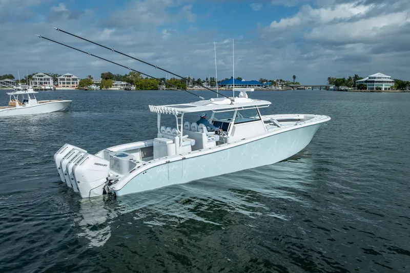 New Stock 42 Offshore Yacht Photos Pics 2026 Yellowfin 42 Offshore boat with multiple engines on a calm waterway.