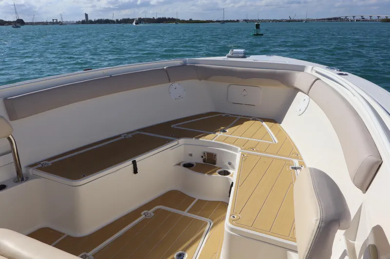  Yacht Photos Pics 2017 Sailfish 320 CC boat interior with cushioned seating and wooden deck, on calm water.