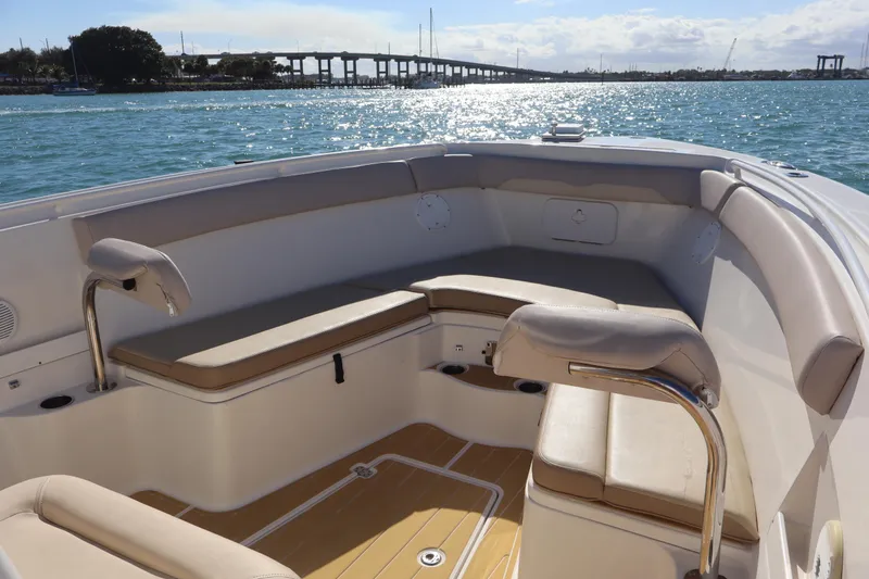  Yacht Photos Pics 2017 Sailfish 320 CC boat interior with cushioned seating, on a sunny day by the water.