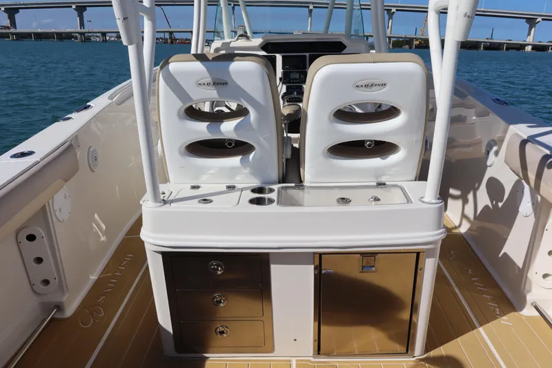 Yacht Photos Pics 2017 Sailfish 320 CC boat interior with dual seats and storage, docked near a bridge.