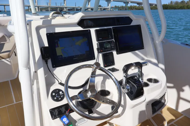  Yacht Photos Pics 2017 Sailfish 320 CC boat dashboard with navigation screens and steering wheel.