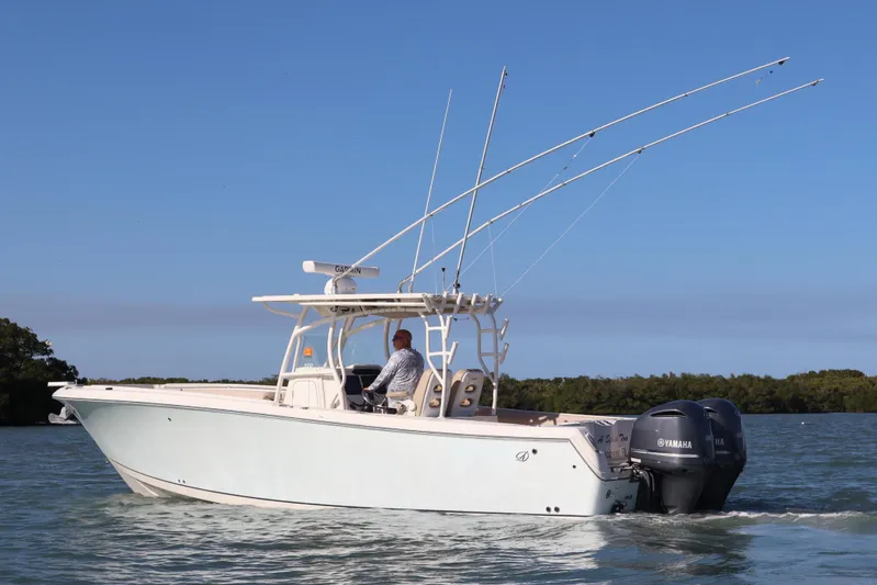  Yacht Photos Pics 2017 Sailfish 320 CC boat cruising on calm waters under clear blue sky.