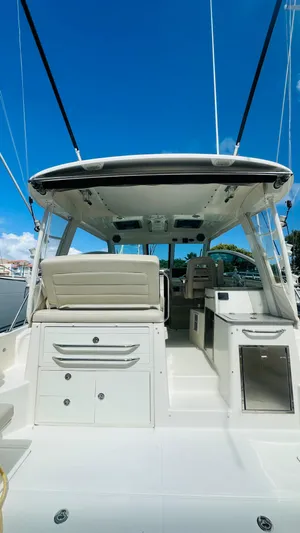  Yacht Photos Pics 2018 Boston Whaler 345 Conquest boat interior with seating and storage, under a clear blue sky.