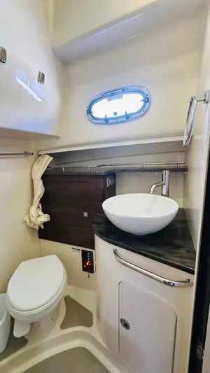  Yacht Photos Pics 2018 Boston Whaler 345 Conquest bathroom with modern sink, toilet, and porthole window.