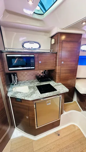  Yacht Photos Pics 2018 Boston Whaler 345 Conquest interior kitchen with modern appliances and wood finish.