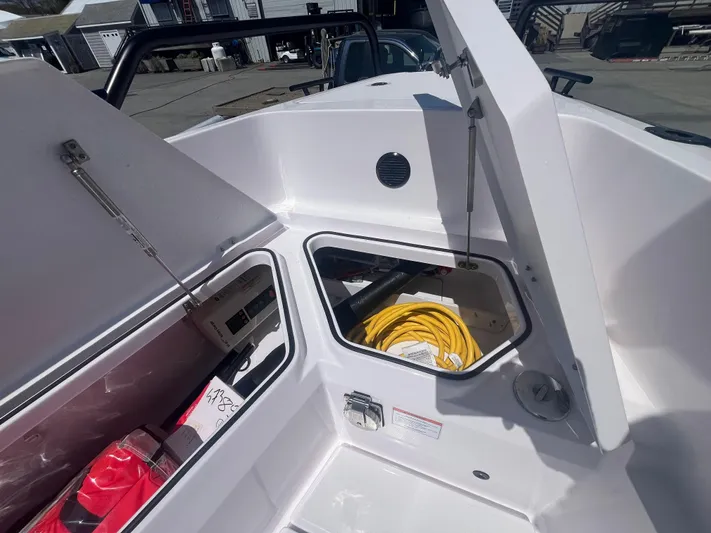  Yacht Photos Pics 2022 Axopar 28 CABIN boat storage compartments with yellow cable and red bag.