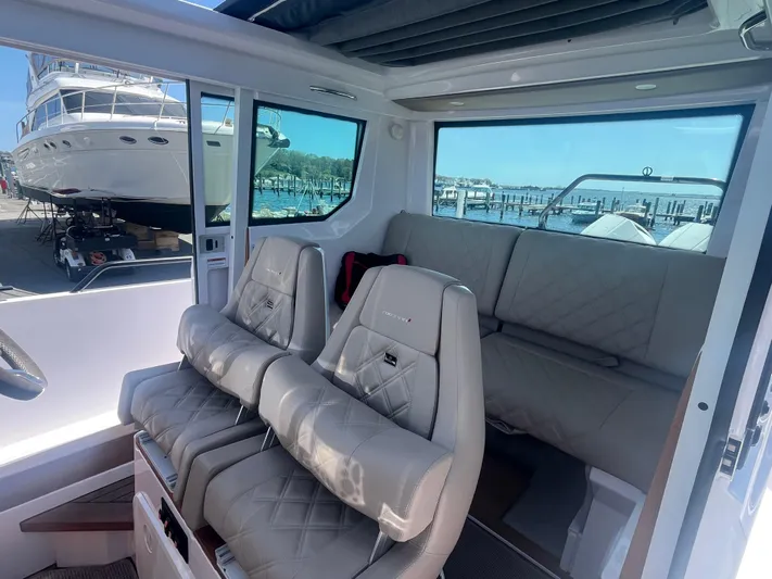  Yacht Photos Pics 2022 Axopar 28 CABIN interior with plush seating and marina view.