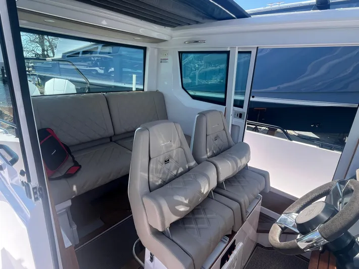  Yacht Photos Pics Interior of 2022 Axopar 28 CABIN boat with seating and steering wheel.