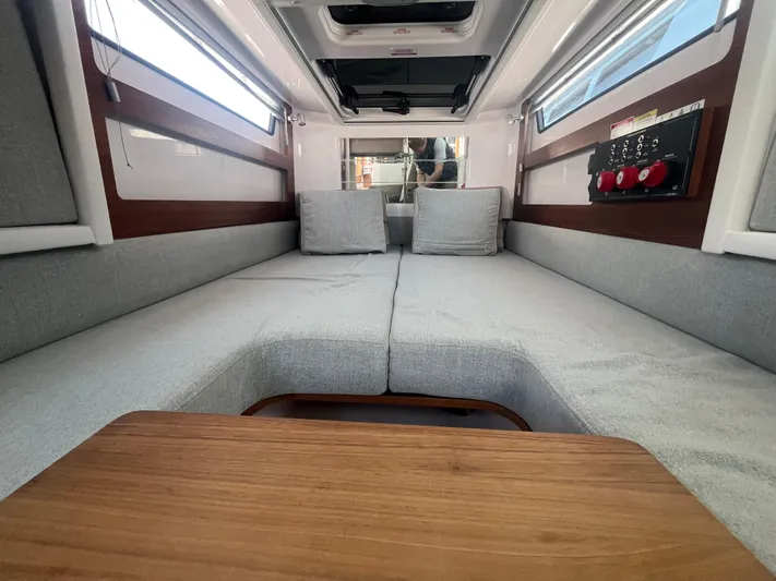  Yacht Photos Pics 2022 Axopar 28 CABIN interior with gray seating and wooden table.