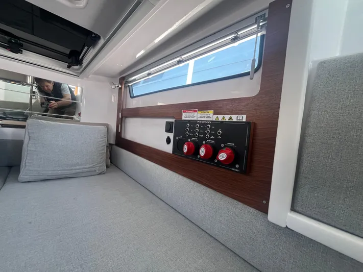  Yacht Photos Pics 2022 Axopar 28 CABIN interior with control panel and cushioned seating.
