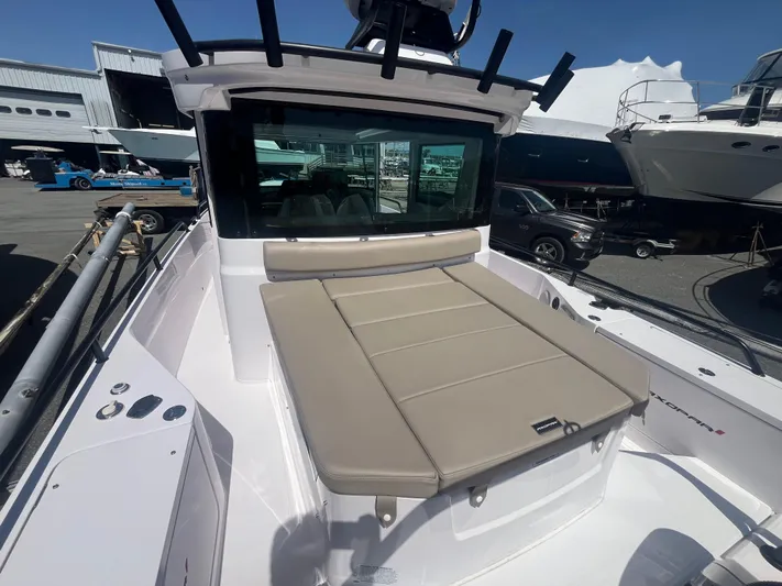  Yacht Photos Pics 2022 Axopar 28 CABIN boat with cushioned deck, docked at a marina.